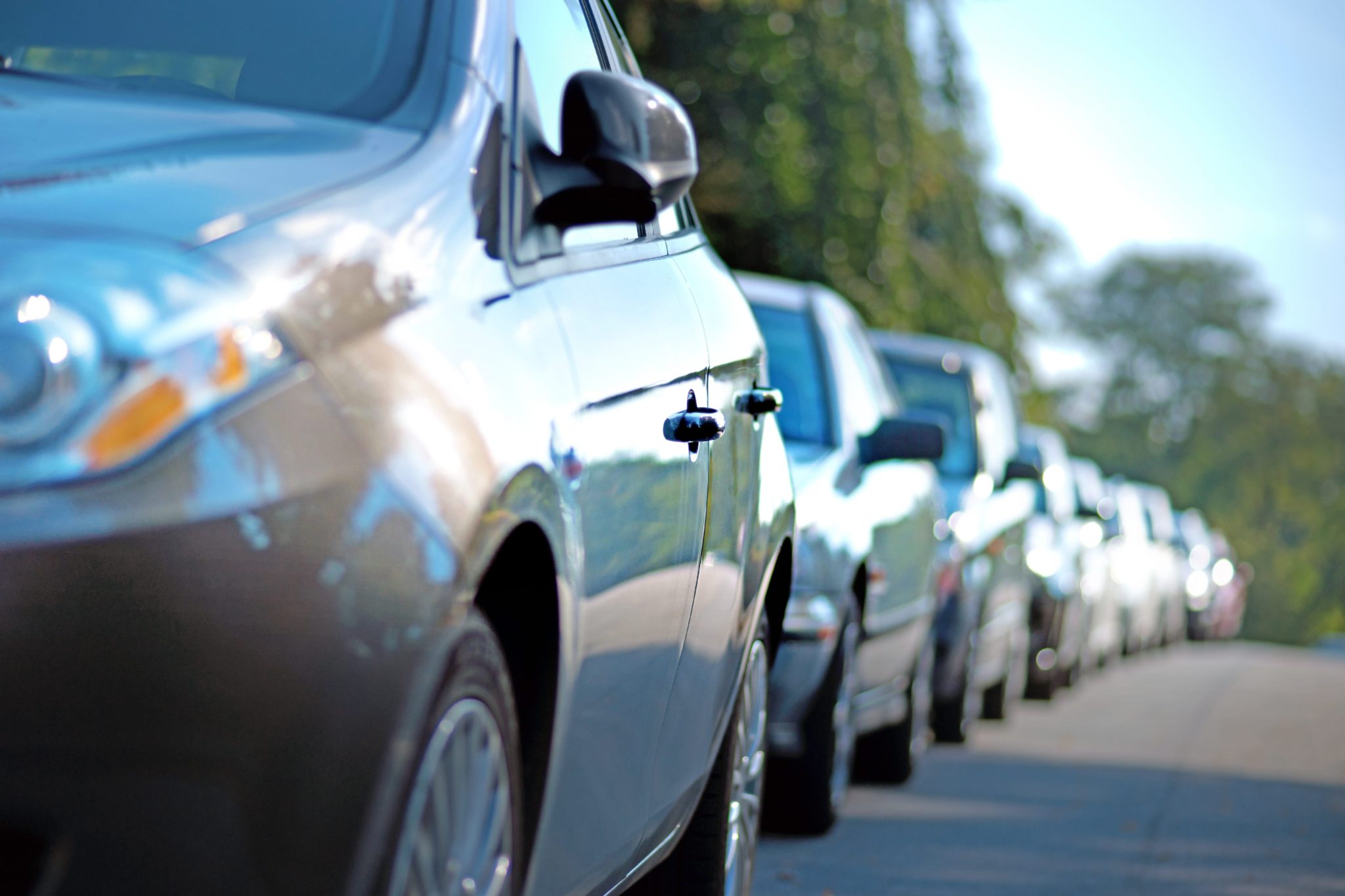 line of parked cars in a neighborhood