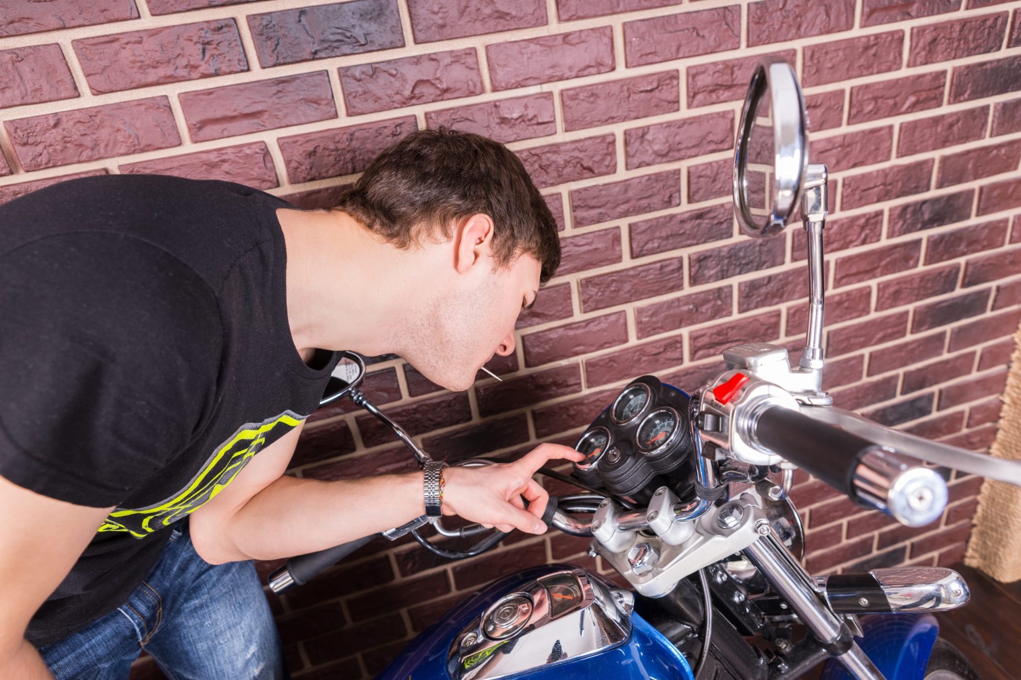 Preparing your motorcycle for transport-Man inspecting gauges on a motorcycle-Motorcycle Shipping