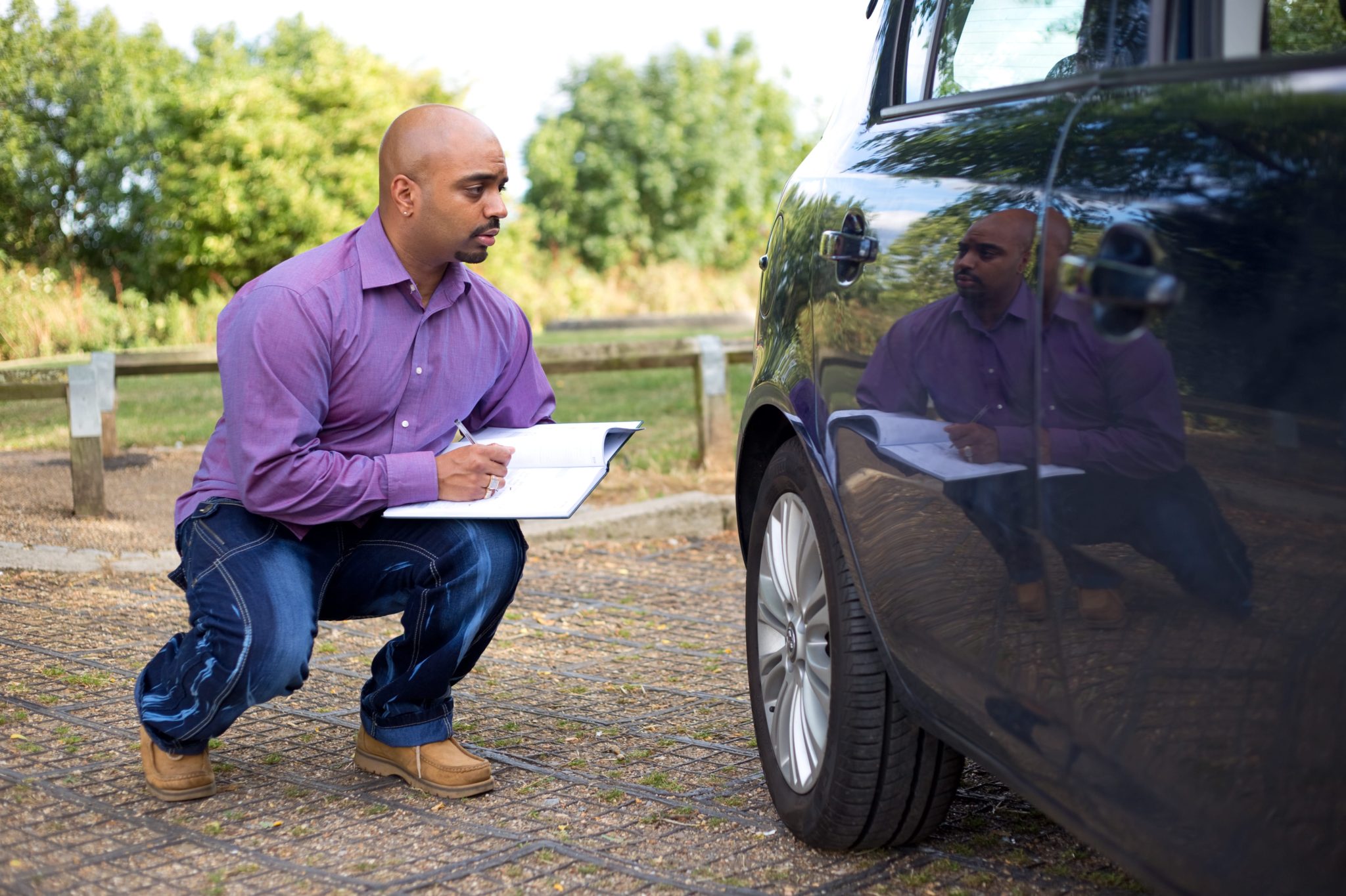 man inspecting a car for transport with SSR Dependable Auto Shippers